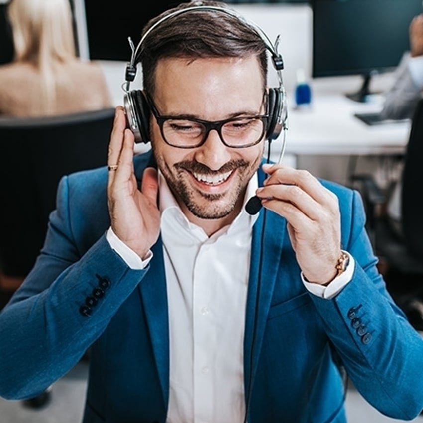 Attraktiver männlicher Kundendienstmitarbeiter, der im Callcenter-Büro als Telemarketer arbeitet.