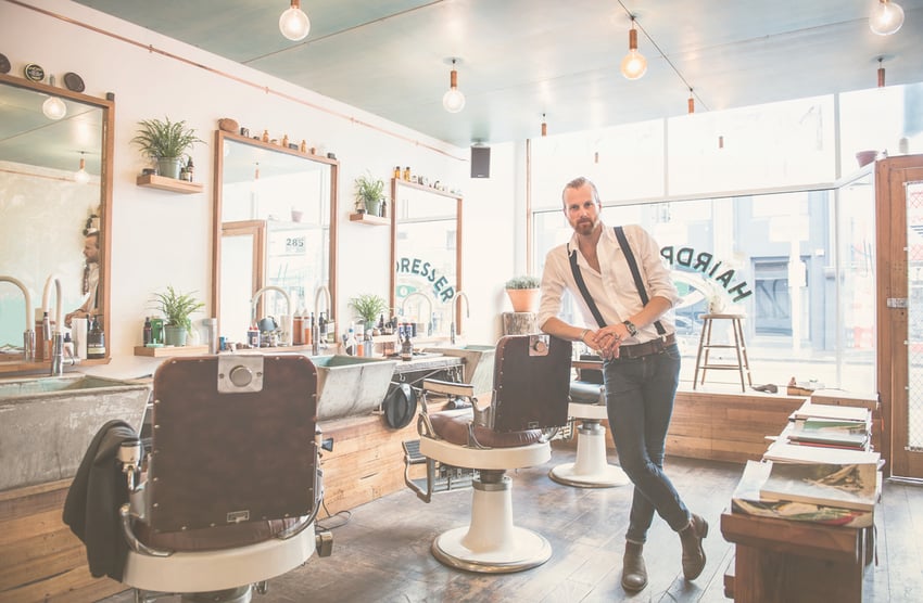 Kaukasischer Stylist lächelt im Friseursalon