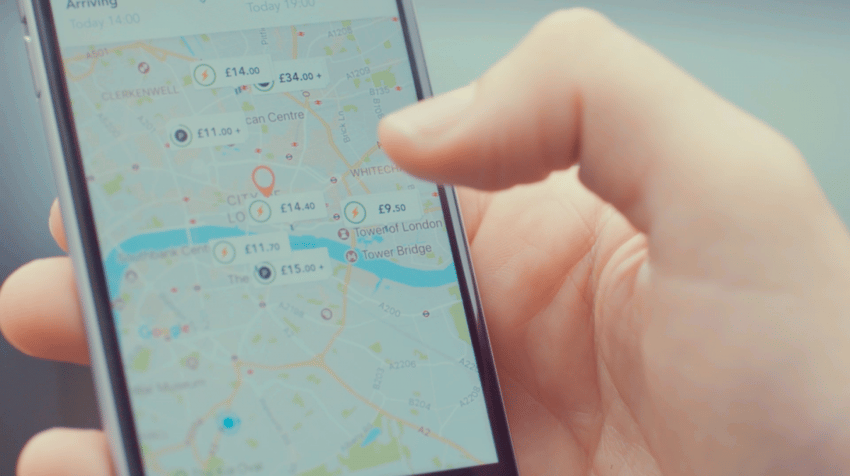 Hand, die ein Mobiltelefon mit geöffneter JustPark-App mit Karte zeigt