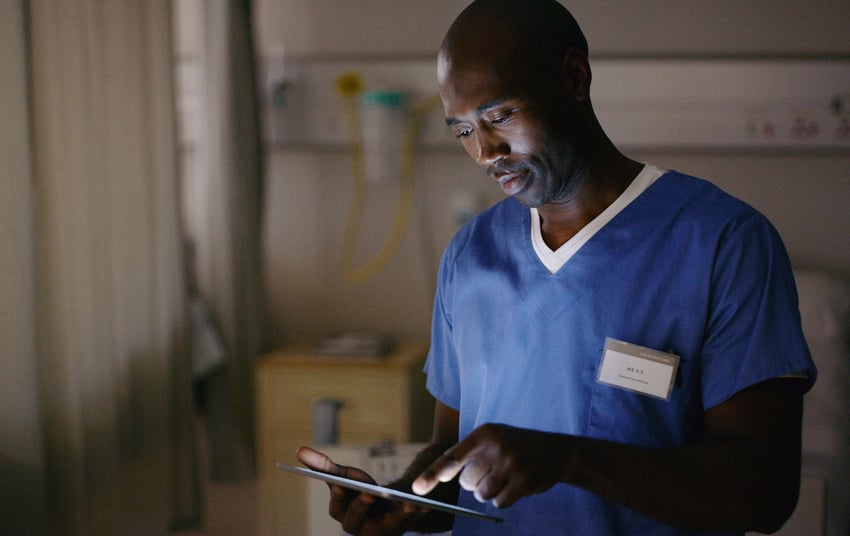 Aufnahme eines Arztes, der ein digitales Tablet verwendet, um ein Krankenblatt zu betrachten