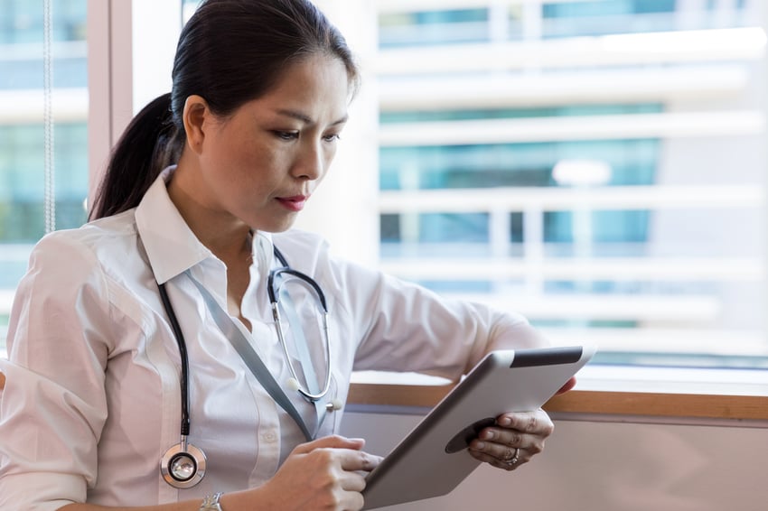 Arzt überprüft Patienteninformationen auf einem Tablet