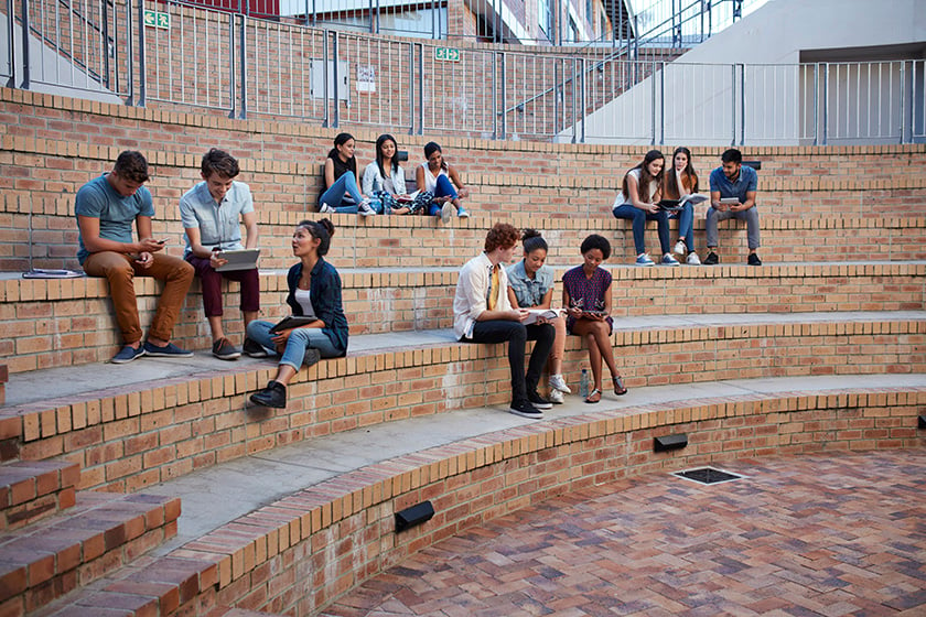 Studenten, die in Gruppen im Freien auf dem Campus lernen